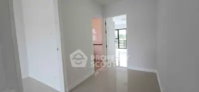 Bright hallway leading to a sunlit room with balcony view
