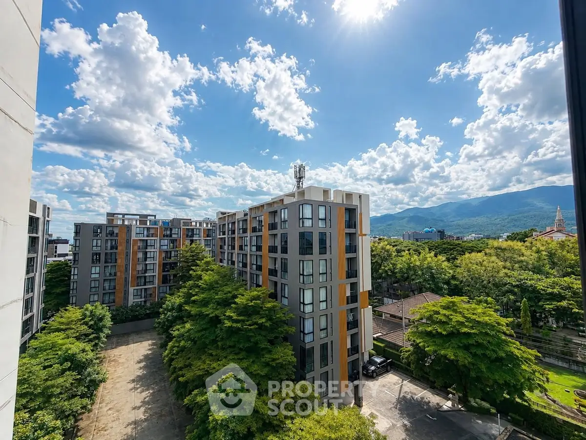 Modern apartment complex with scenic mountain views and lush greenery