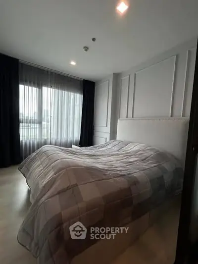 Cozy bedroom with modern decor and large window for natural light