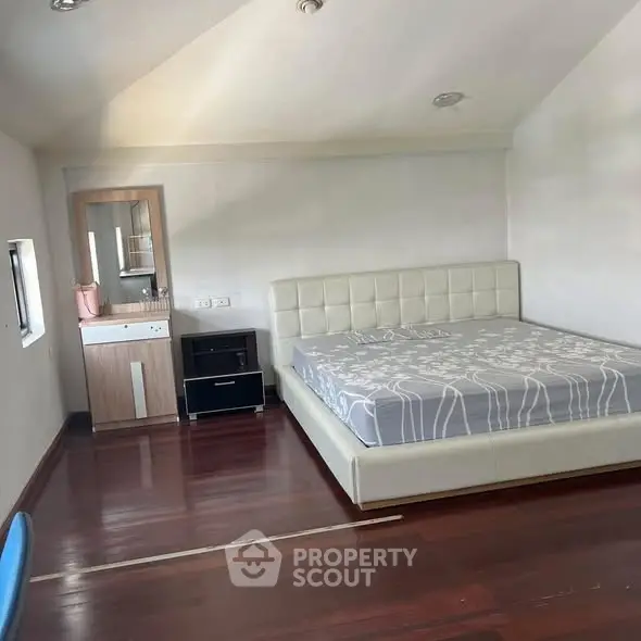 Spacious bedroom with modern bed and hardwood floors