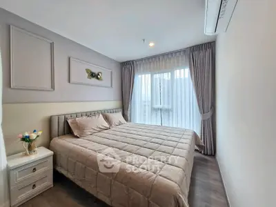 Modern bedroom with elegant decor and large window offering natural light