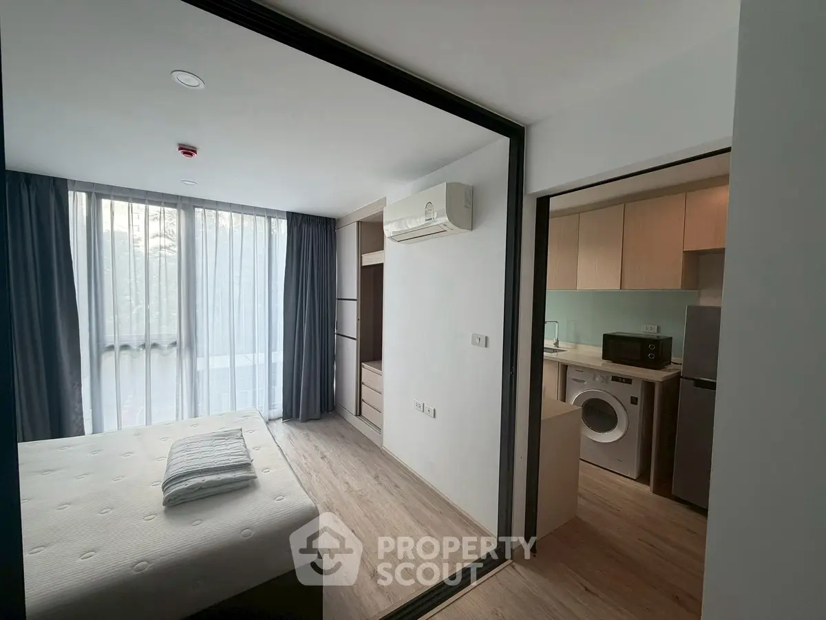Modern studio apartment with bedroom and kitchen, featuring air conditioning and washing machine.