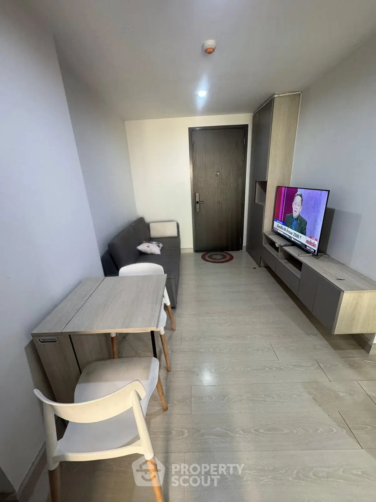 Modern living room with sleek furniture and wall-mounted TV in a cozy apartment.