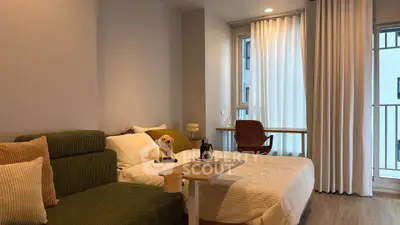Cozy bedroom with modern decor and natural light, featuring a comfortable bed and stylish seating area.