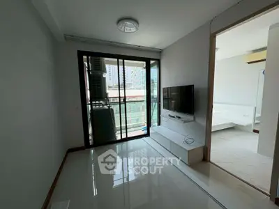 Modern living room with balcony and sleek TV setup in urban apartment