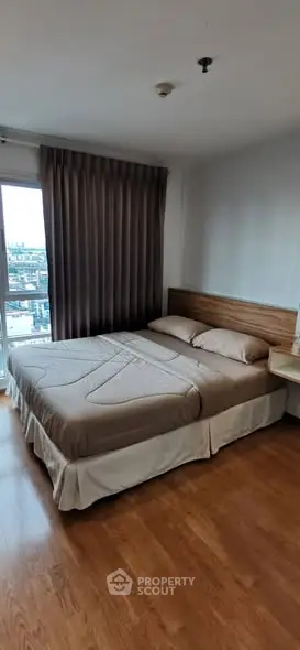 Cozy bedroom with city view and elegant wooden flooring