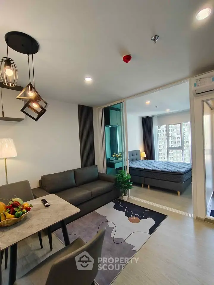 Modern open-plan living room with stylish decor and adjacent bedroom in a contemporary apartment.