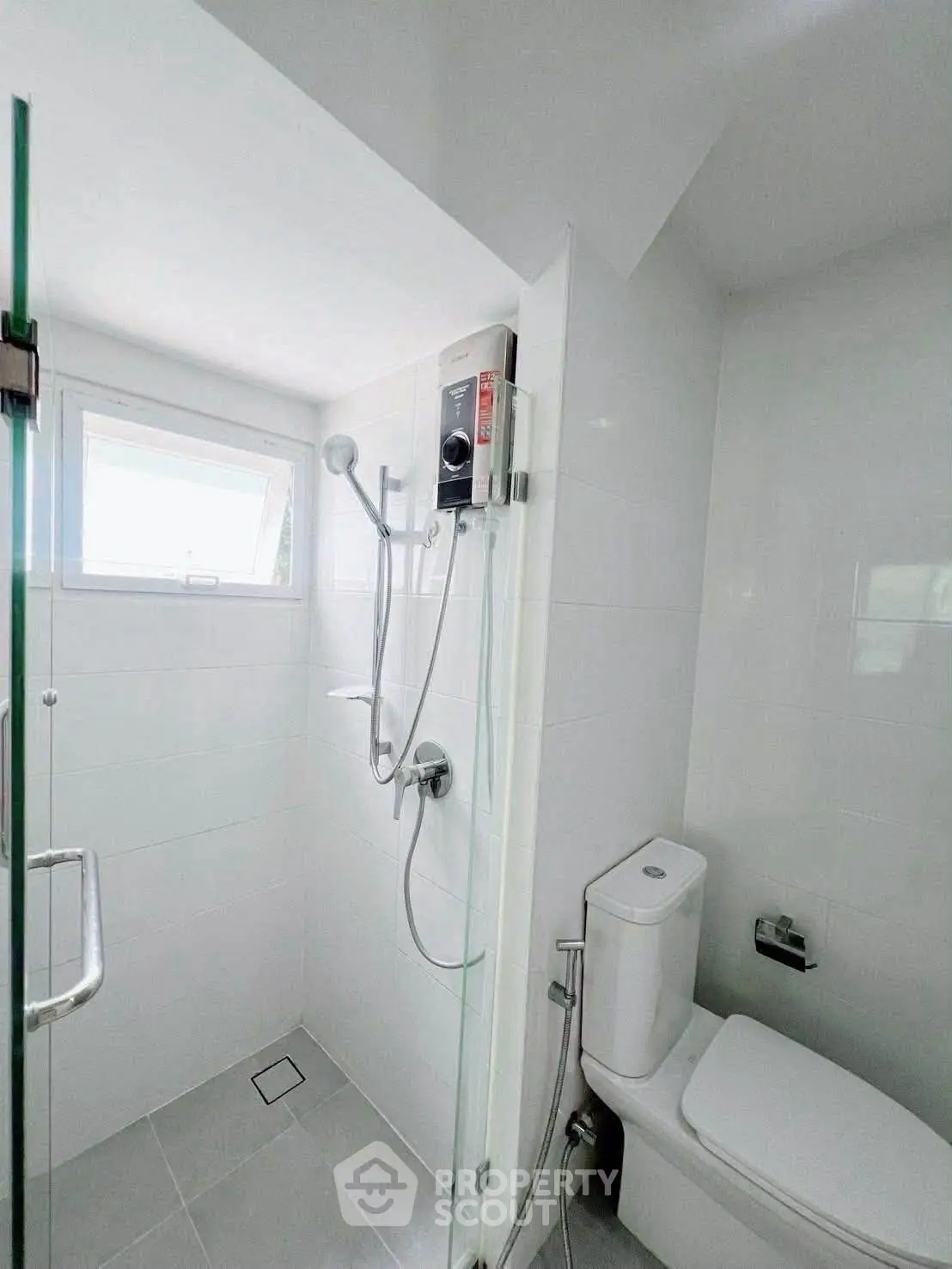 Modern bathroom with shower and toilet in a bright, minimalist design.