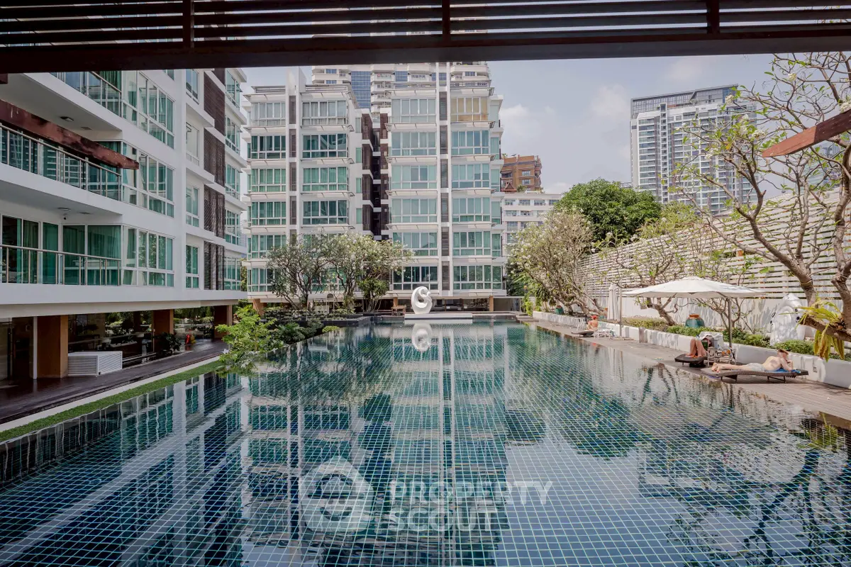 Luxurious condominium with stunning pool and modern architecture in urban setting.