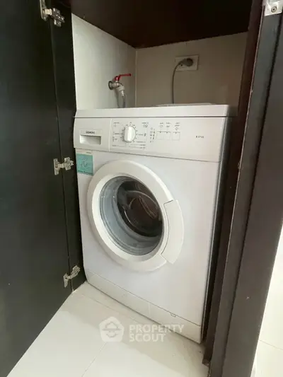 Compact washing machine neatly installed in a modern kitchen cabinet