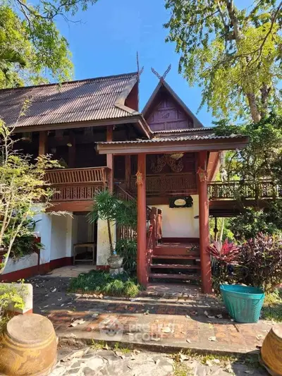 Charming traditional wooden house with lush garden and rustic architecture.