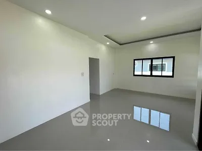 Spacious minimalist living room with glossy tiled floor and recessed lighting.