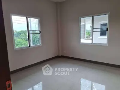 Spacious empty room with large windows and glossy tiled floor, ideal for customization.