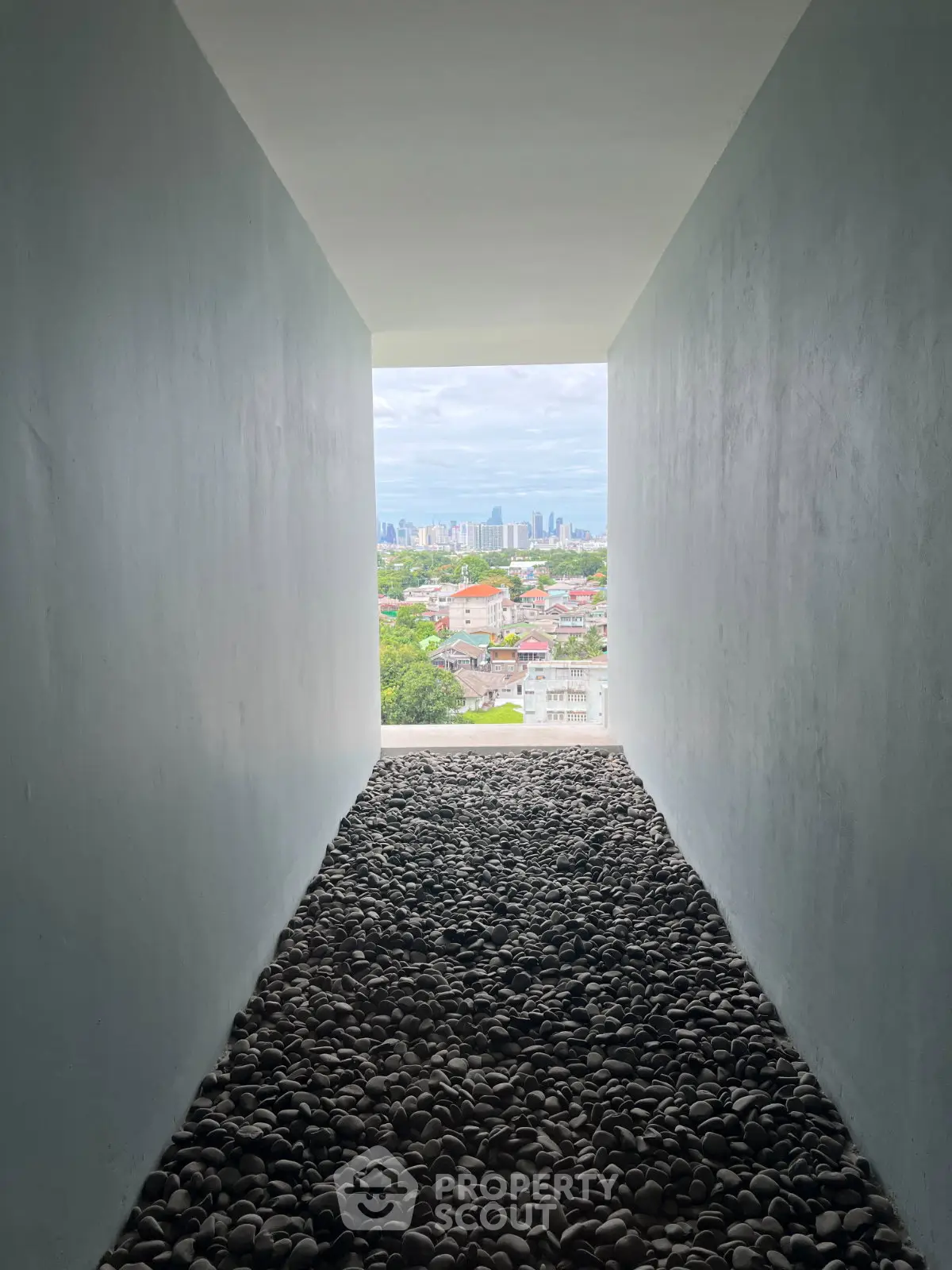 Stunning cityscape view from a modern architectural corridor with pebble stone flooring.