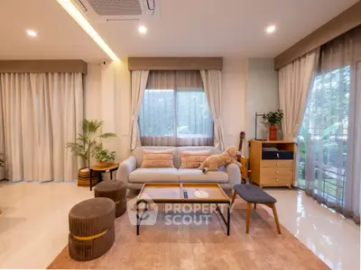 Spacious modern living room with cozy seating and large windows offering natural light.