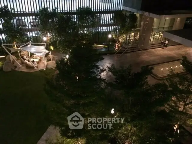 Luxurious nighttime view of modern building with elegant garden and ambient lighting.