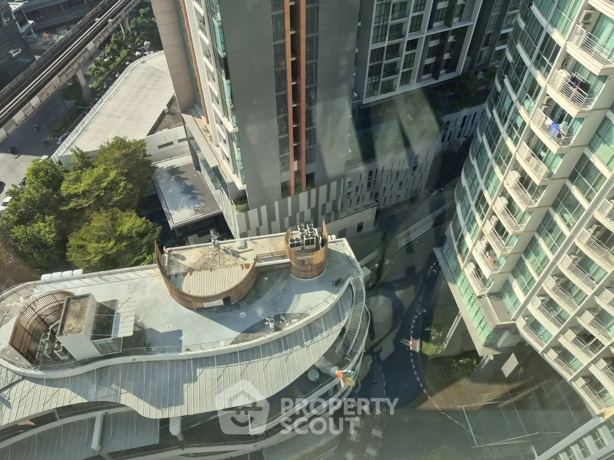 Stunning aerial view of modern high-rise buildings with lush greenery and urban surroundings.