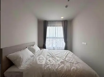 Cozy bedroom with large window and soft lighting, perfect for relaxation.
