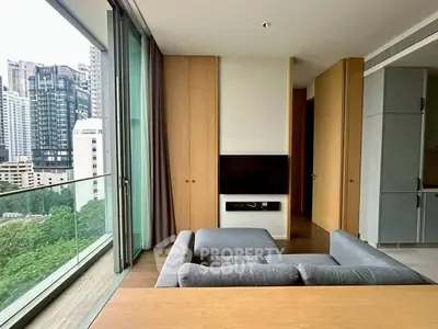 Modern living room with city view and sleek furniture in high-rise apartment.