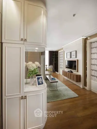 Elegant living room with modern decor, wooden flooring, and built-in storage cabinets.