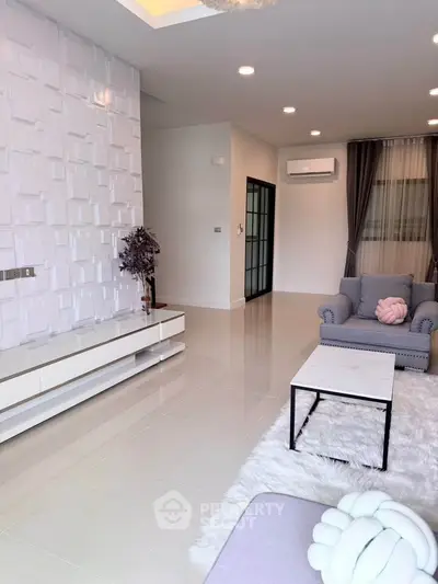 Spacious modern living room with elegant decor and plush seating in a stylish home.