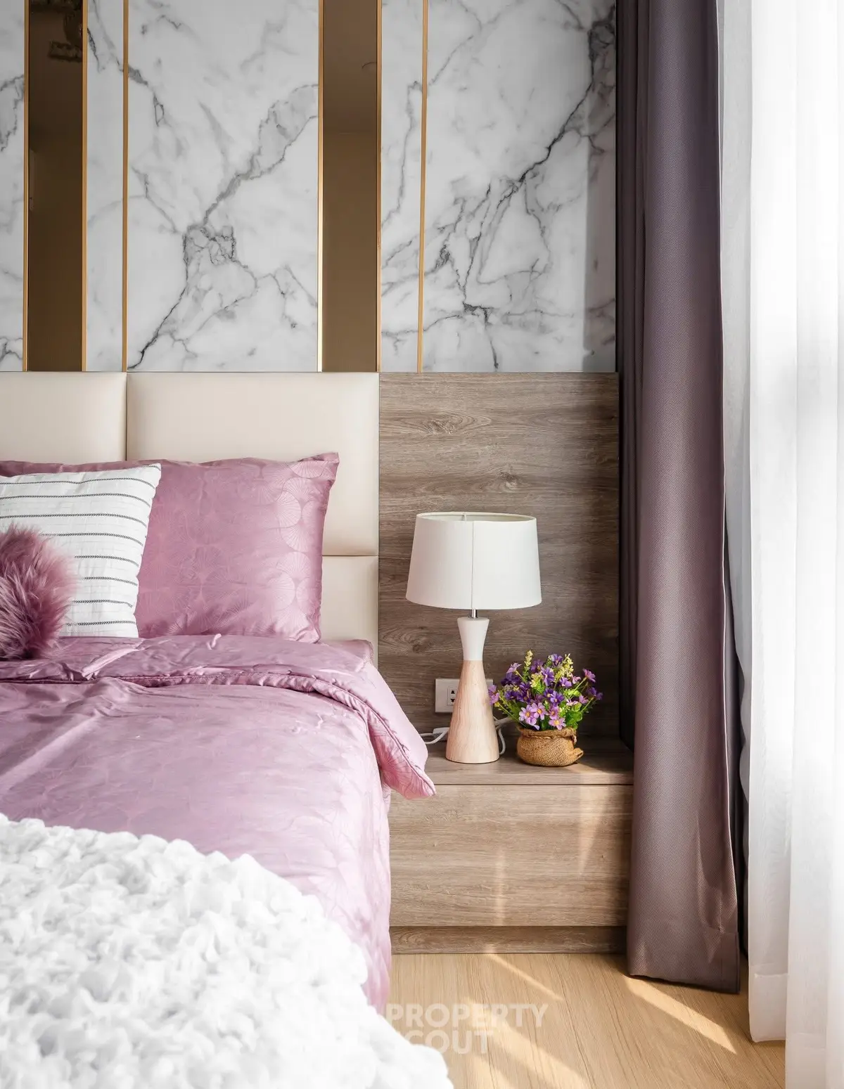 Luxurious bedroom with elegant marble accent wall and plush bedding