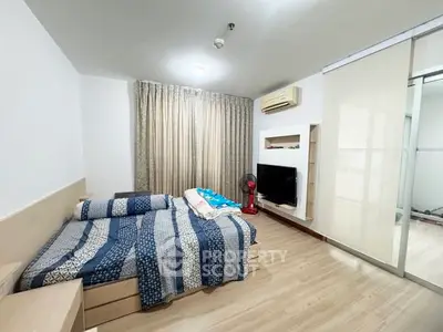 Cozy bedroom with modern decor, featuring a comfortable bed, air conditioning, and a sleek TV setup.