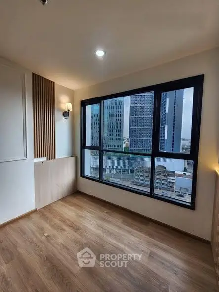 Modern apartment with large windows offering stunning city views and elegant wooden flooring.