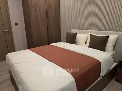 Modern bedroom with stylish decor and cozy bedding in a contemporary apartment.