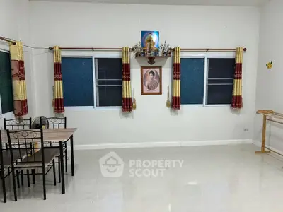 Spacious room with dining table and religious decor, ideal for versatile living space.