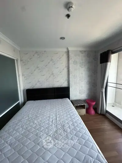 Cozy bedroom with modern decor and balcony access in a stylish apartment.