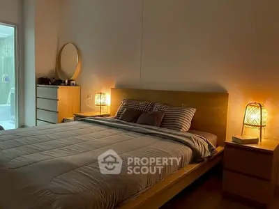 Cozy bedroom with warm lighting and modern furnishings, perfect for relaxation.