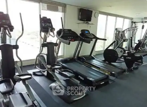 Spacious modern gym with state-of-the-art fitness equipment and large windows.