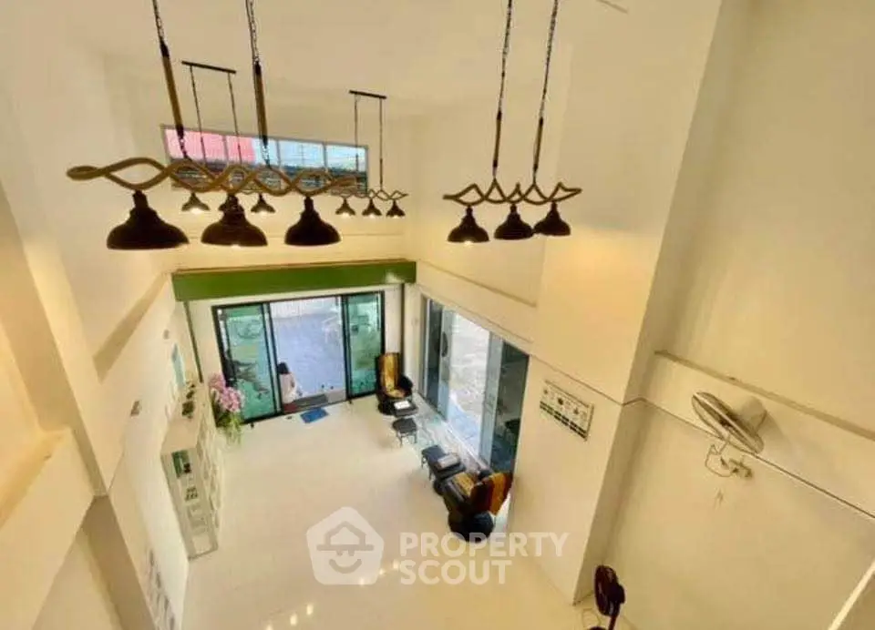 Spacious modern living room with high ceiling and elegant lighting