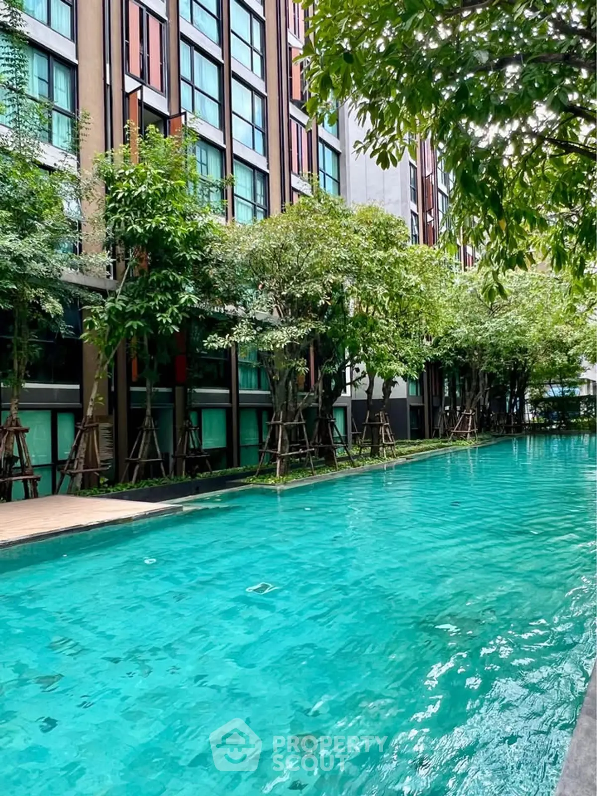 Luxurious apartment complex with stunning pool and lush greenery