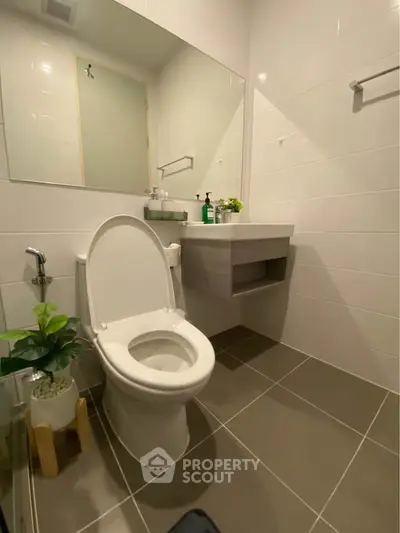 Modern bathroom with sleek fixtures and stylish tile flooring.