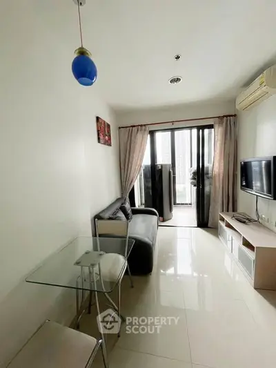 Modern living room with sleek furniture and balcony view in a stylish apartment.