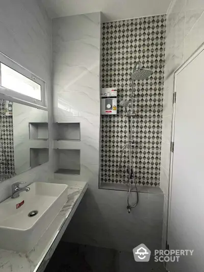 Modern bathroom with elegant marble tiling, walk-in shower featuring a stylish patterned accent wall, and sleek fixtures, perfect for a contemporary home.