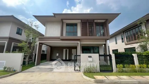 Modern two-story house with sleek design and spacious driveway in suburban neighborhood.