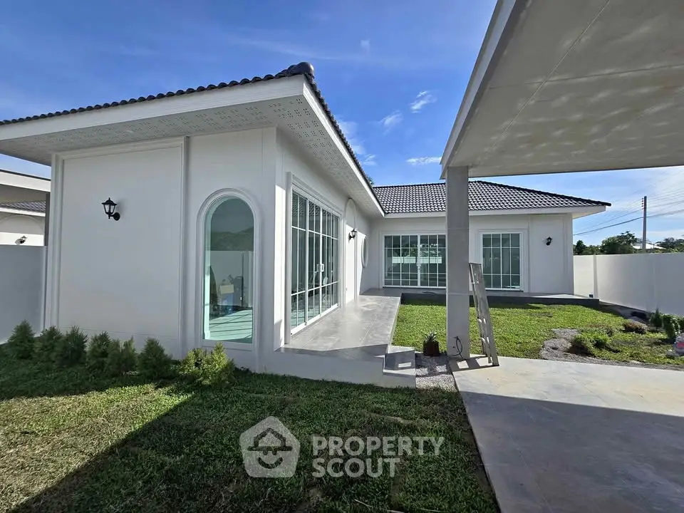Modern single-story house with large windows and landscaped garden