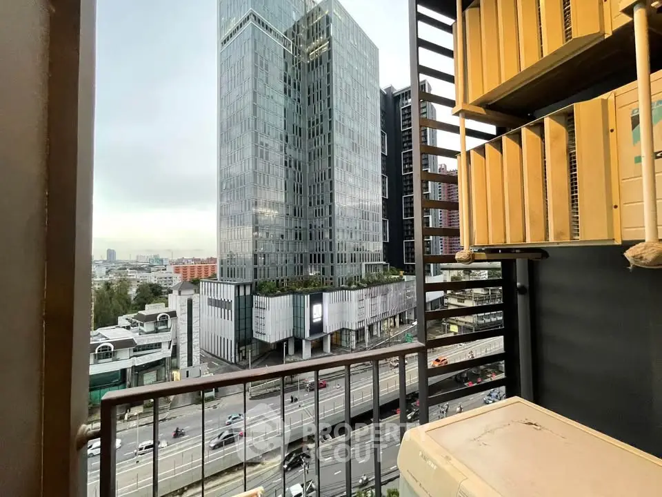 Stunning urban view from a high-rise balcony overlooking modern skyscrapers and bustling city streets.