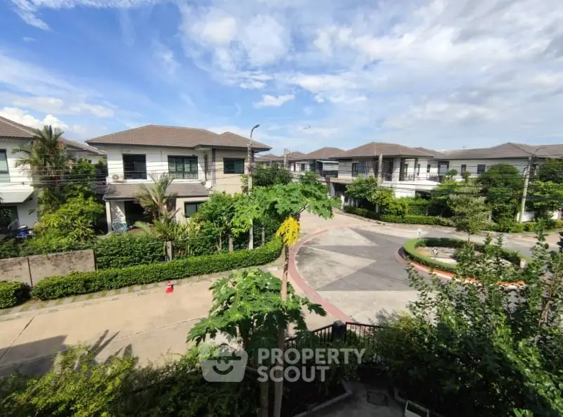 Charming suburban neighborhood with modern houses and lush greenery under a clear blue sky.
