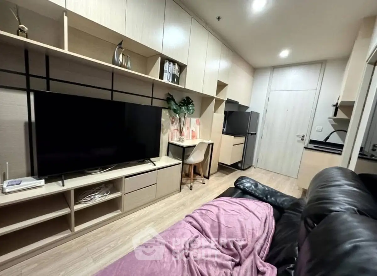 Modern living room with sleek built-in storage and large TV, perfect for cozy relaxation.