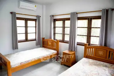 Bright bedroom with twin beds and large windows in modern home