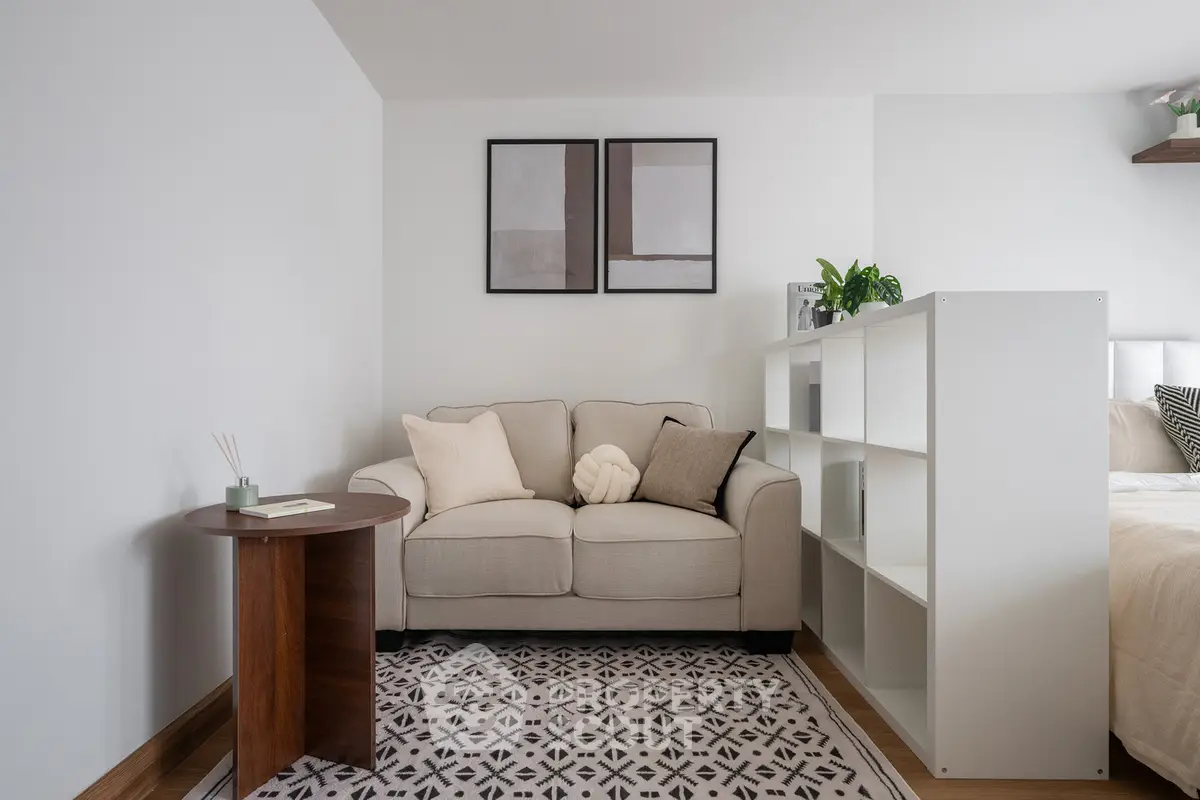 Cozy living room with modern decor and neutral tones, featuring a comfortable sofa and stylish artwork.