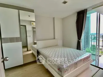 Modern bedroom with large window and city view, featuring a comfortable bed and sleek design.