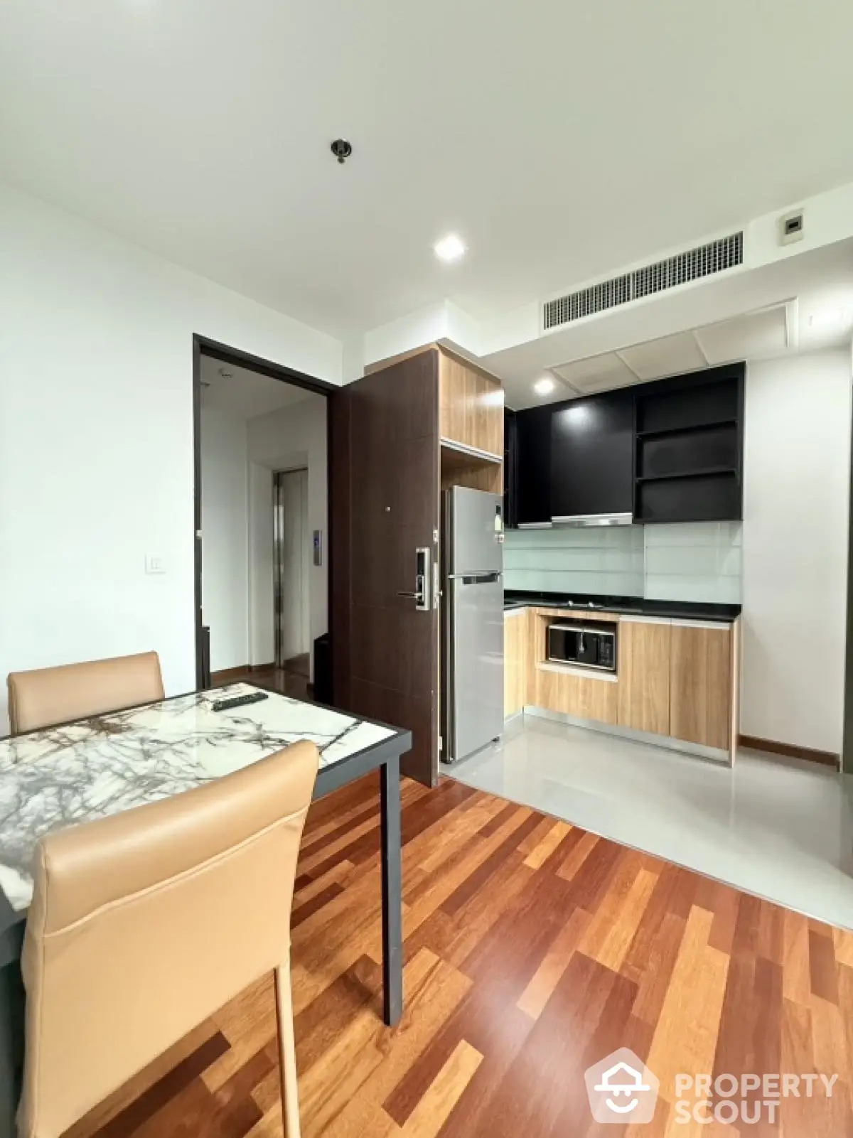 Modern kitchen with sleek cabinetry and dining area in stylish apartment