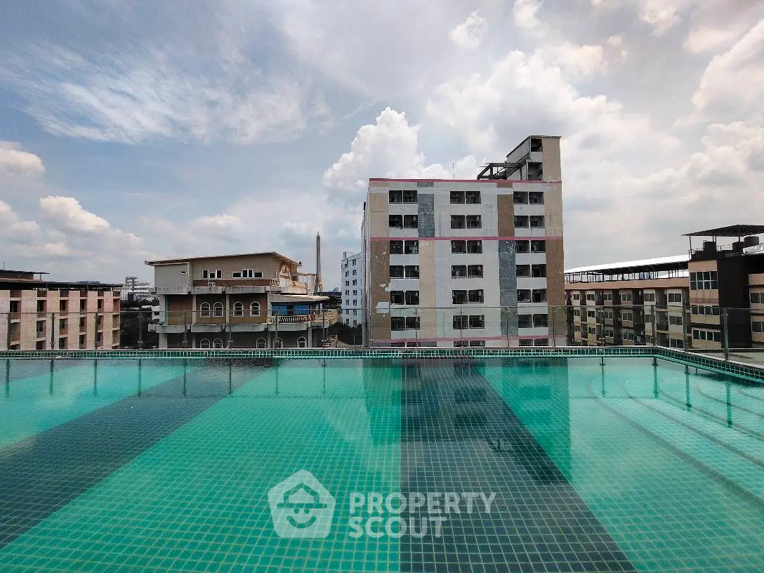 Stunning rooftop pool with cityscape view under a bright sky.