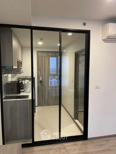 Modern compact kitchen with glass sliding doors and sleek cabinetry