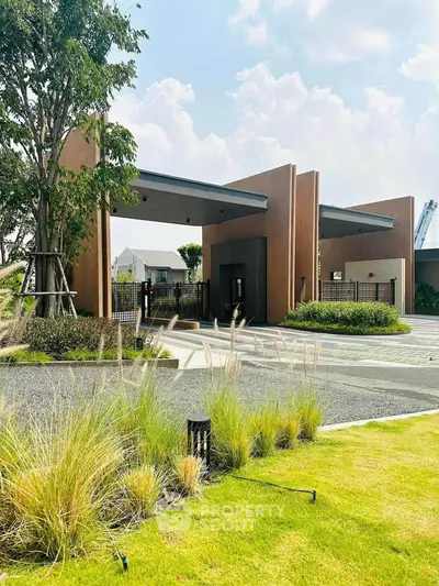 Modern architectural entrance with lush landscaping and sleek design elements.